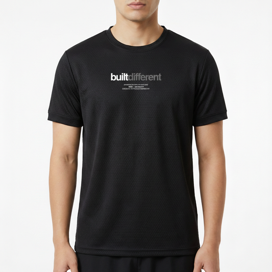 Camiseta com estampa frontal de "built different" em fonte destacada, acompanhada de texto menor descrevendo mensagens motivacionais.