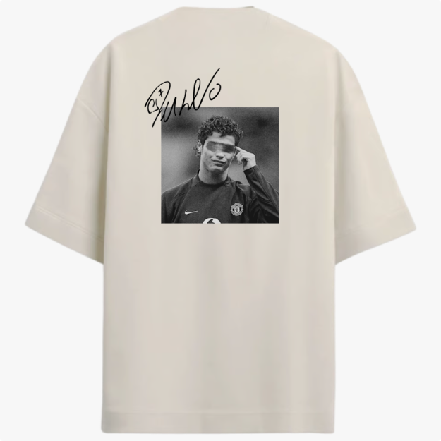 Camiseta com estampa traseira de fotografia em preto e branco de um jogador de futebol em campo, sobreposta por assinatura estilizada brilhante.