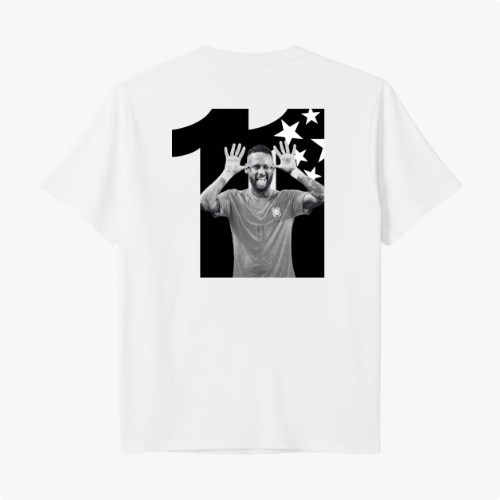 Camiseta com estampa traseira de número grande acompanhando imagem central de jogador de futebol em pose alegre, ladeado por estrelas estilizadas.