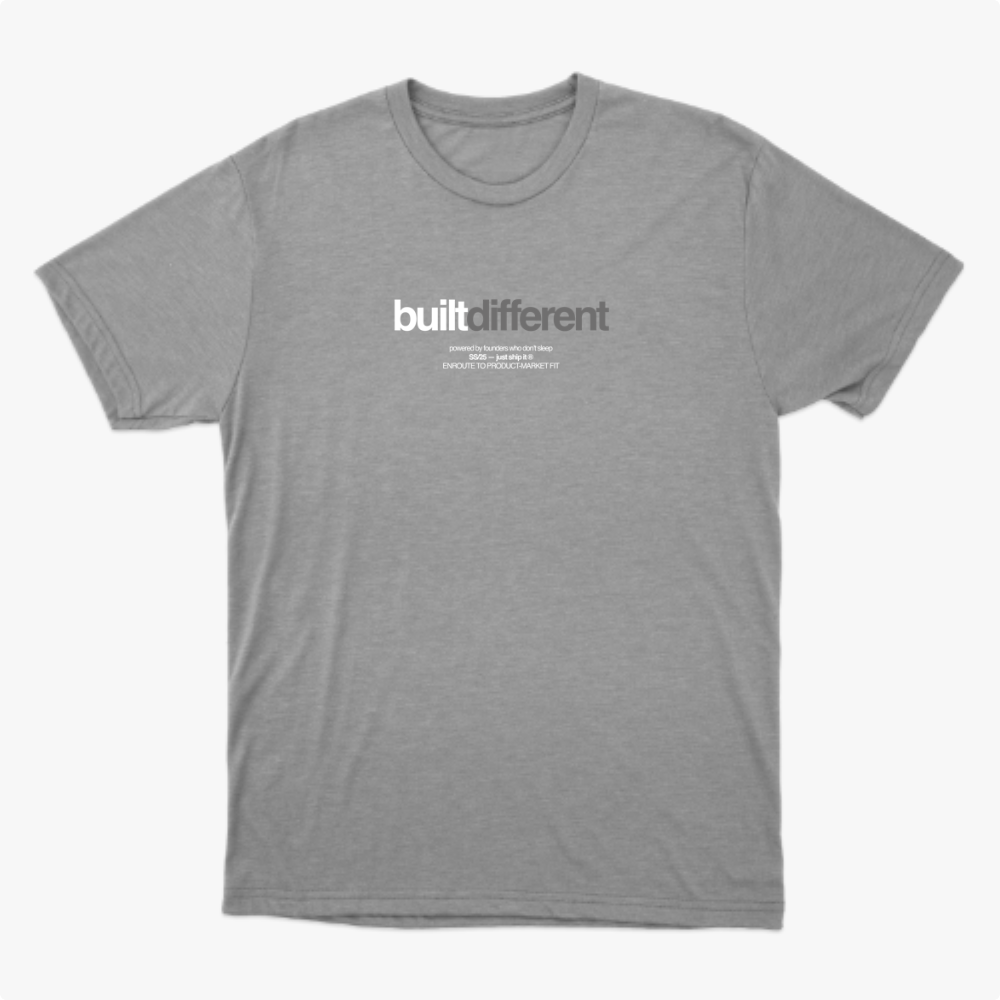 Camiseta com estampa frontal de texto estilizado "built different" acompanhado de frases menores alinhadas abaixo, sugerindo um conceito único e marcante.