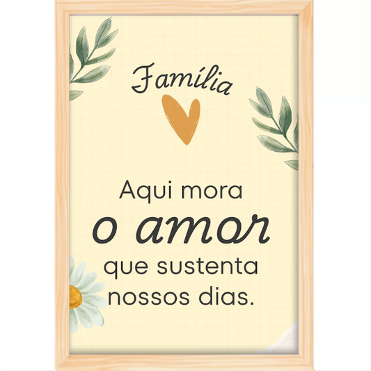 Quadro com estampa de mensagem "Família Aqui mora o amor que sustenta nossos dias" entre ramos de folhas, coração laranja e margarida.