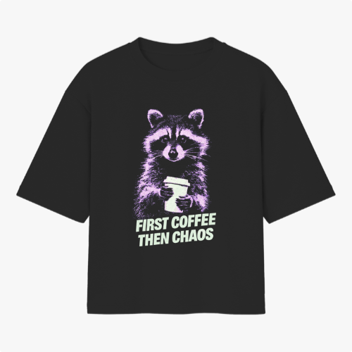 Camiseta com estampa frontal de guaxinim segurando um copo, acompanhada da frase "FIRST COFFEE THEN CHAOS" em estilo tipográfico destacado.