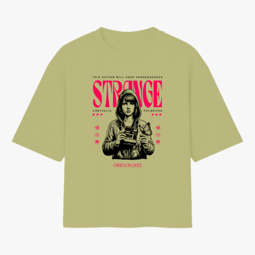 Camiseta com estampa frontal de personagem segurando uma câmera, com itens gráficos ao redor e texto estilizado em destaque, incluindo "Strange" e "Oregon 2013".