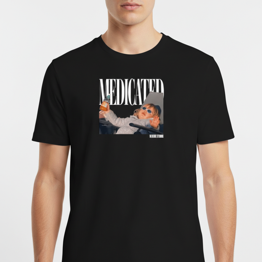Camiseta com estampa frontal de fotografia de bebê com óculos escuros segurando uma mamadeira, acompanhada da palavra "MEDICATED" em letras grandes.