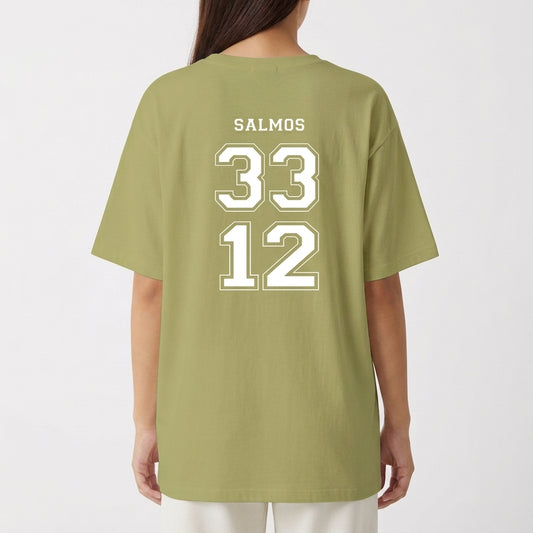 Camiseta com estampa frontal de frase inspiradora acompanhada de um brasão estilizado e estampa traseira com a palavra "SALMOS" acima dos números "33" e "12".
