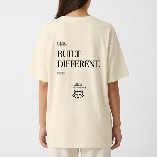 Camiseta com estampa frontal de texto estilizado "RACCONTEAM" e estampa traseira de frase "BUILT DIFFERENT." com símbolo e coordenadas detalhadas.