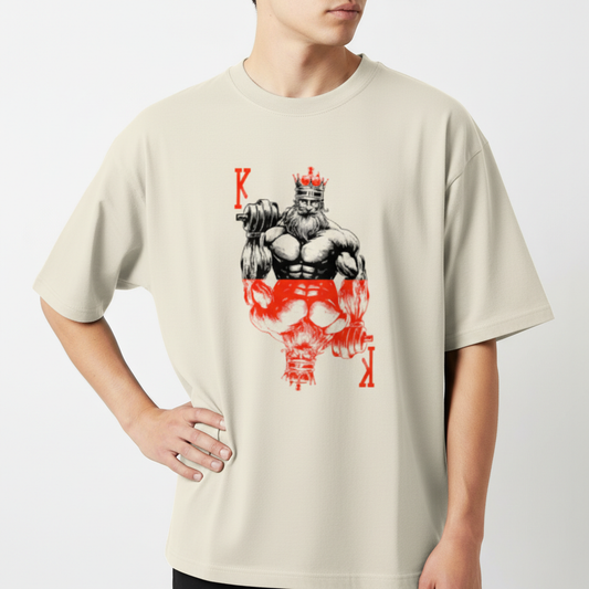 Camiseta com estampa frontal de um rei musculoso segurando um haltere, adornado com uma coroa e cercado por letras K estilizadas verticalmente.