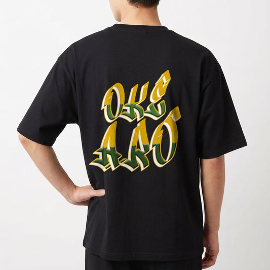 Camiseta com estampa traseira de letras grandes e estilizadas, formando a expressão "OKE AAO" com detalhes em efeito tridimensional destacando a mensagem.
