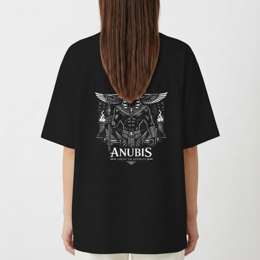 Camiseta com estampa frontal de "Seravia" em letras estilizadas e detalhe ornamental, e estampa traseira de Anúbis, o deus egípcio, com asas e tochas.