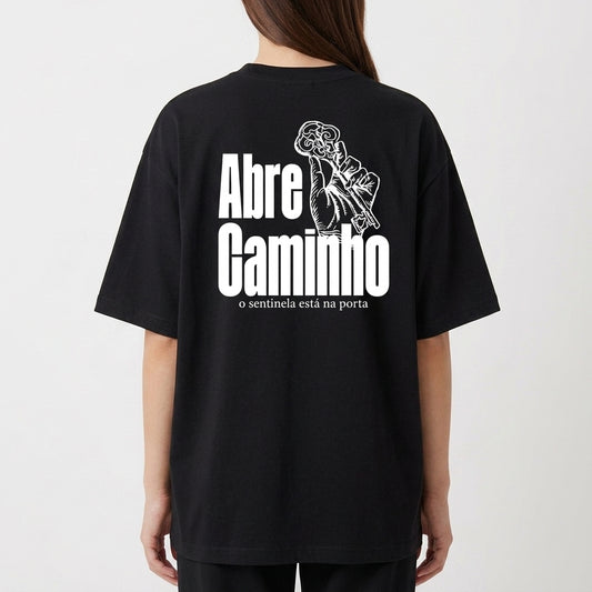 Camiseta com estampa frontal de chaves cruzadas e estampa traseira de mão segurando chave, junto com a frase "Abre Caminho o sentinela está na porta".