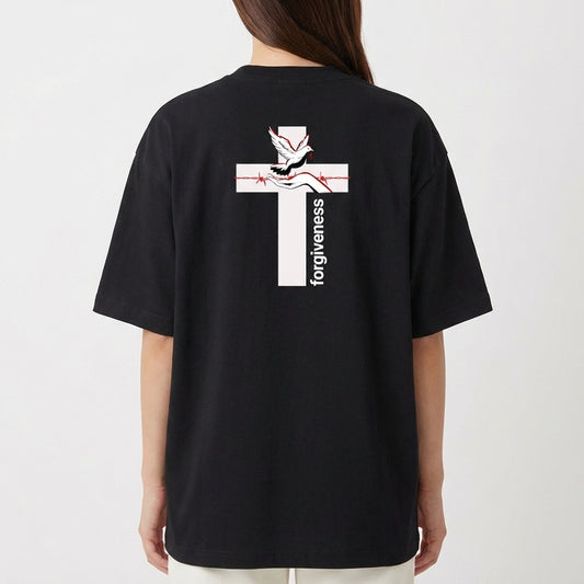 Camiseta com estampa frontal de uma construção em estilo clássico e texto pequeno, e estampa traseira de uma cruz com uma pomba, mãos rezando e a palavra "forgiveness".