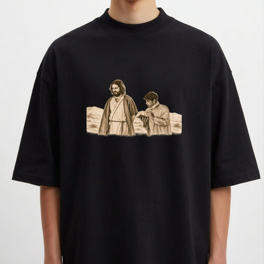 Camiseta com estampa frontal de duas figuras históricas em trajes antigos, uma olhando para frente e outra lendo um livro, em um cenário desértico.