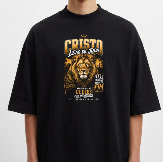 Camiseta com estampa frontal de um leão majestoso cercado por textos em estilo impactante, incorporando elementos de poder, fé e espiritualidade.