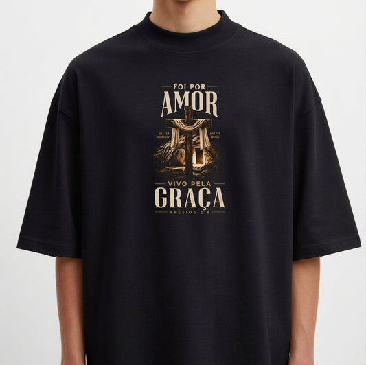 Camiseta com estampa frontal de uma cruz entre colunas clássicas, rodeada por folhagens e frase "Foi por amor, vivo pela graça - Efésios 2:5".