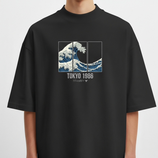 Camiseta com estampa frontal de onda estilizada em três painéis e texto centralizado "Tokyo 1986" seguido de "TITANIFF" em letras menores.