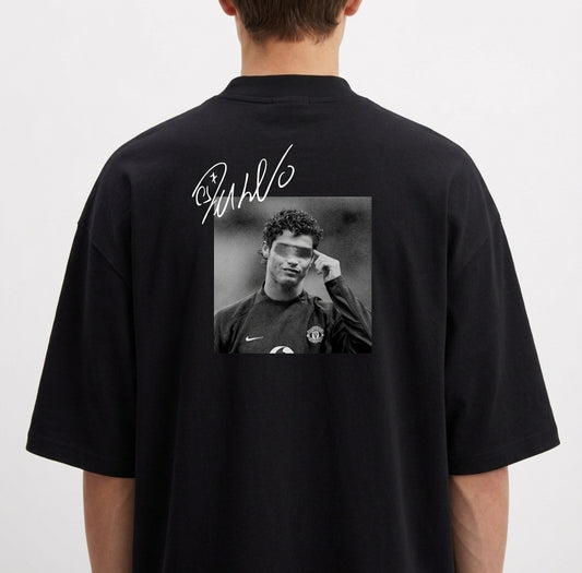 Camiseta com estampa traseira de fotografia em preto e branco de um jogador de futebol em campo, sobreposta por assinatura estilizada brilhante.