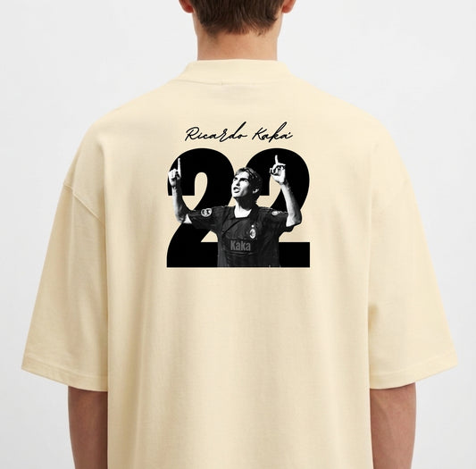 Camiseta com estampa traseira de jogador celebrando, sobreposta ao número 22, com assinatura estilizada acima.