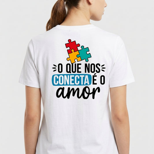 Camiseta com estampa frontal de "AUTISMO" acompanhado de mãos e frase "Ser diferente é normal" e estampa traseira de peças de quebra-cabeça com "O QUE NOS CONECTA É O amor".