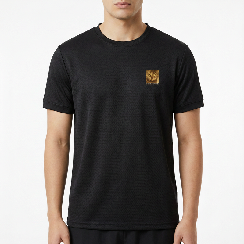 Camiseta com estampa frontal de um símbolo dourado detalhado posicionado do lado esquerdo do peito, acompanhado de um texto abaixo da imagem.