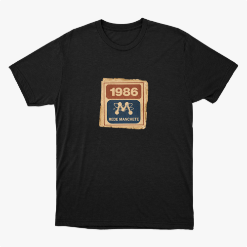 Camiseta com estampa frontal de um selo retangular retrô com o ano "1986" no topo e a inscrição "Rede Manchete" abaixo, separado por um símbolo estilizado.