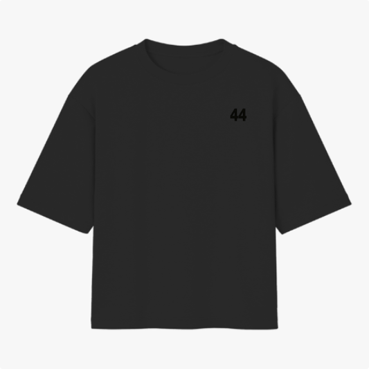 Camiseta com estampa frontal de número "44" pequeno no peito e estampa traseira de piloto segurando bandeira do Brasil, sobreposição de textos.