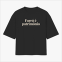 Camiseta com estampa frontal de texto "Forró é patrimônio" e estampa traseira com pequeno logotipo circular acima de texto menor centralizado.