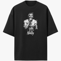 Camiseta com estampa frontal de uma figura masculina segurando um microfone, envolta de efeitos gráficos, com o nome "Nelly" em letras cursivas abaixo.