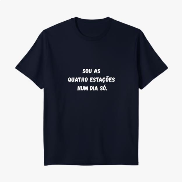 Camiseta com estampa frontal de texto em forma de frase que diz "SOU AS QUATRO ESTAÇÕES NUM DIA SÓ." em fonte de estilo marcante e legível.
