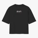 Camiseta com estampa frontal de olhos estilizados em quadrados e texto "SASUKE", e estampa traseira de ilustração em quadrado de personagem sério com cabelo escuro.