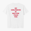 Camiseta com estampa traseira de frases em destaque: "MY GIRLFRIEND IS HOTTER THAN YOU", distribuídas em quatro linhas com uma tipografia marcante.