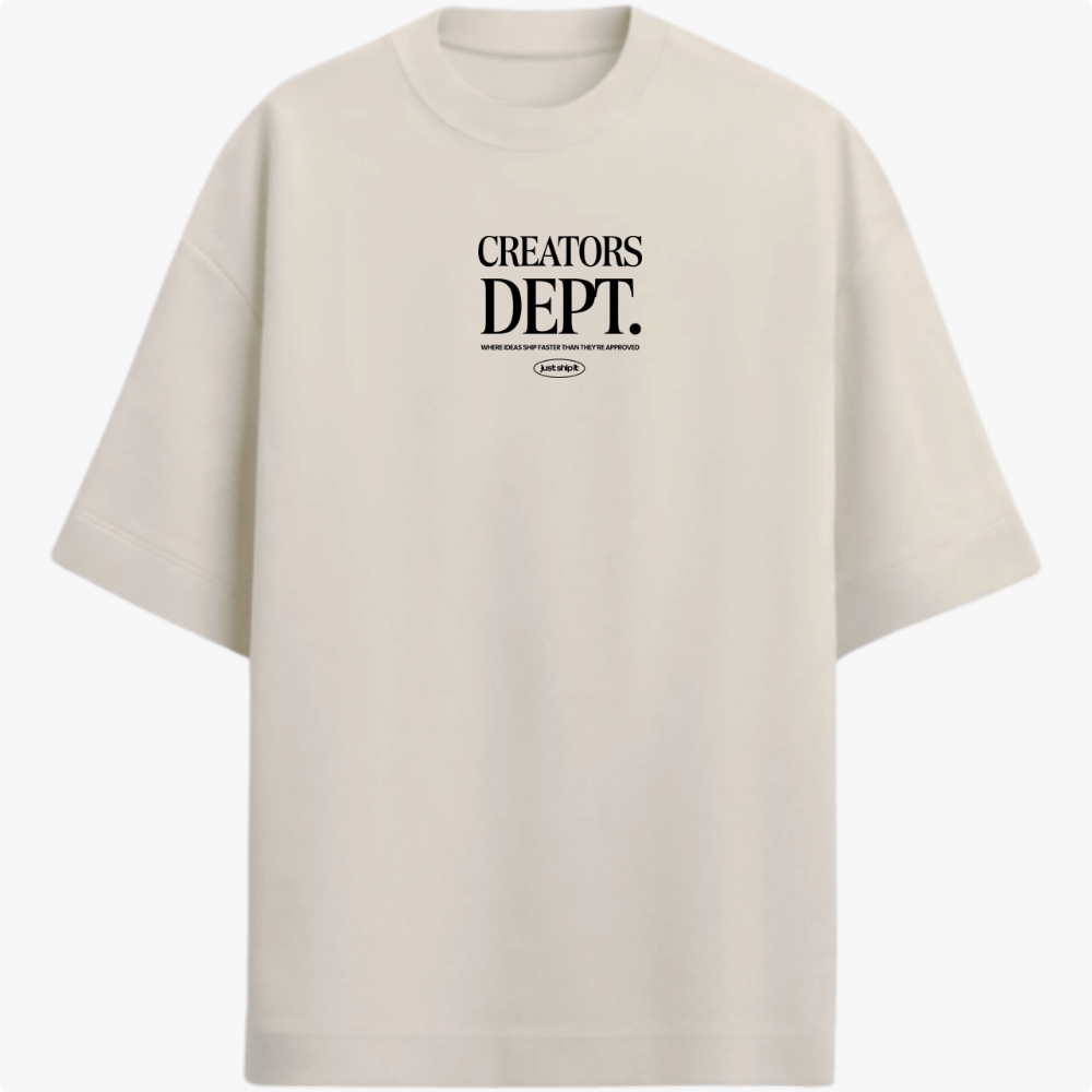 Camiseta com estampa frontal de texto "CREATORS DEPT." em destaque, acompanhada por uma frase menor e logo oval discretamente posicionada abaixo.