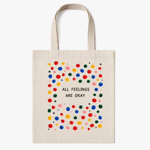 Ecobag com estampa frontal de círculos coloridos esparsos ao redor de texto centralizado dizendo "ALL FEELINGS ARE OKAY", criando um design vibrante.