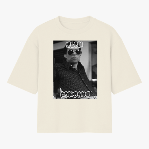Camiseta com estampa frontal de fotografia em preto e branco de uma pessoa usando óculos escuros, com texto estilizado acima e abaixo da imagem.