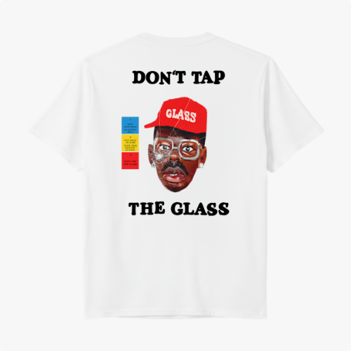 Camiseta com estampa frontal de martelo e texto "Don't Tap The Glass" e estampa traseira de rosto com boné, texto e blocos coloridos ao lado.
