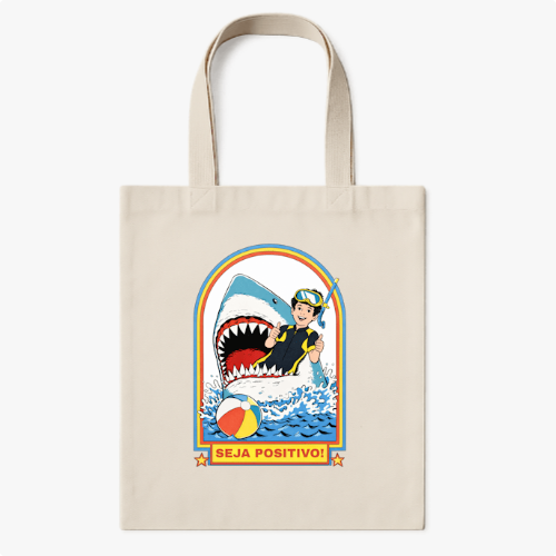 Ecobag com estampa frontal de uma cena divertida de um garoto surfando ao lado de um tubarão, bola de praia colorida à frente, com frase "Seja Positivo!".