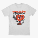 Camiseta com estampa frontal de coração animado segurando uma flor murcha, com adesivo e olhar entediado, rodeado por estrelas e texto "Corazón Aburrido".