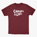 Camiseta com estampa frontal de letras estilizadas "Carranca & Labs" e estampa traseira de um desenho gráfico de figura caricata com expressão marcante.