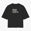 Camiseta com estampa frontal de texto "silêncio. o brasil tá jogando." com assinatura "FALAR, NÃO MURMURAR." e estampa traseira de "VERDELO" no topo.