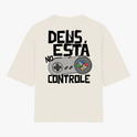 Camiseta com estampa frontal de logo pequeno escrito “VIGIA” no centro e estampa traseira de controle de videogame com frase “DEUS ESTÁ NO CONTROLE”.