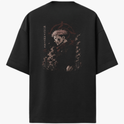 Camiseta com estampa frontal de personagem com máscara e detalhes sutis, e estampa traseira de personagem imponente cercado por sombras e prédios estilizados.