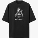 Camiseta com estampa frontal de cantor segurando microfone com colares, tatuagens e a frase "Pop Smoke" logo abaixo da imagem detalhada.