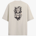 Camiseta com estampa frontal de rosto estilizado e estampa traseira de figuras sombrias sobrepostas, incluindo um lobo feroz e uma personificação misteriosa.