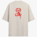 Camiseta com estampa frontal de "No Mercy Club" em estilo gotejante e estampa traseira de cobra desenhada com detalhes ousados em estilo gráfico.