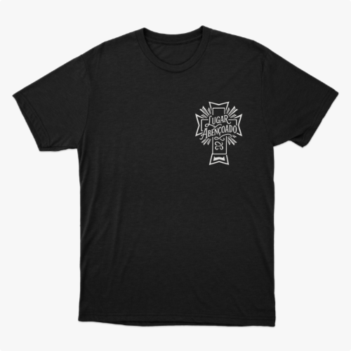 Camiseta com estampa frontal de cruz contendo a frase "Lugar abençoado" e símbolo decorativo, e estampa traseira de texto "LAB" em destaque.
