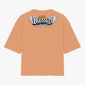 Camiseta com estampa frontal de um pequeno símbolo de leão com coroa e estampa traseira de asas estilizadas com a palavra "Blessed" e auréola acima.