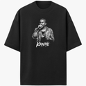 Camiseta com estampa frontal de um cantor segurando um microfone, vestindo jaqueta e colares, acompanhada pelo nome "Kanye" estilizado abaixo.