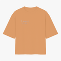 Camiseta com estampa frontal de texto em letras simples "Il raccolto è inevitabile." e estampa traseira de vaso azul com três flores amarelas e caule verde.