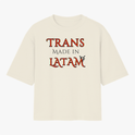 Camiseta com estampa frontal de palavras "TRANS MADE IN LATAM" em estilo icônico, enriquecida por um detalhe gráfico de morcego elegante.