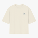 Camiseta com estampa frontal de uma pequena onda estilizada, acompanhada por elementos celestiais como estrelas e uma lua crescente acima dela.