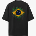Camiseta com estampa frontal de pequeno emblema circular estilizado no canto superior e estampa traseira de bandeira do Brasil em efeito de respingos de tinta.